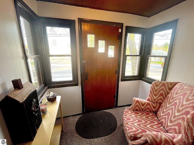 foyer with carpet floors and wood ceiling