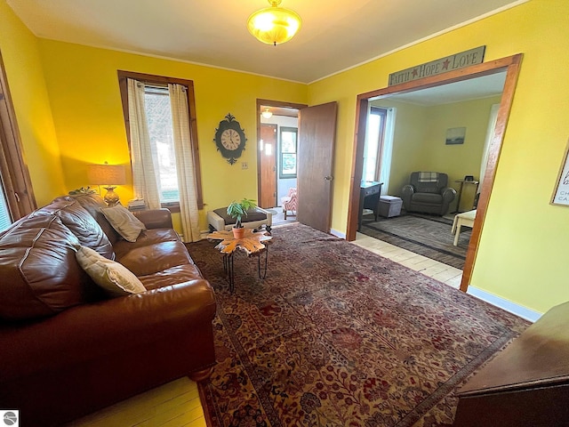 living area with baseboards, a wealth of natural light, and light wood-style floors