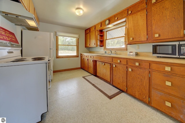 kitchen with white electric range oven, stainless steel microwave, under cabinet range hood, and brown cabinets