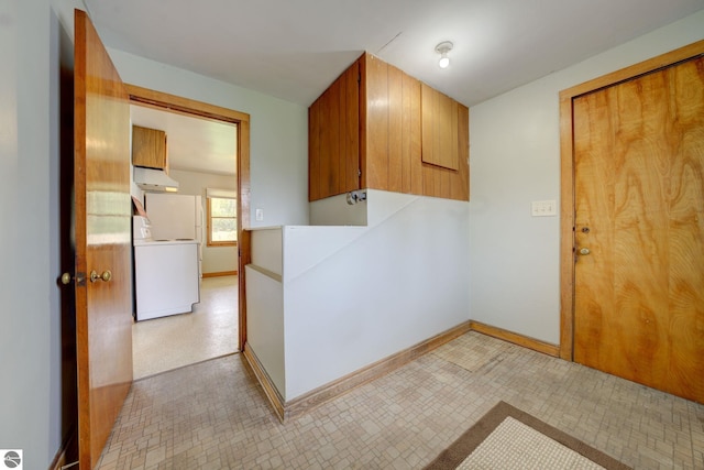 interior space with baseboards, cabinet space, washer / clothes dryer, and light floors