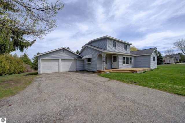 view of front of home featuring a front lawn, covered porch, and a detached garage