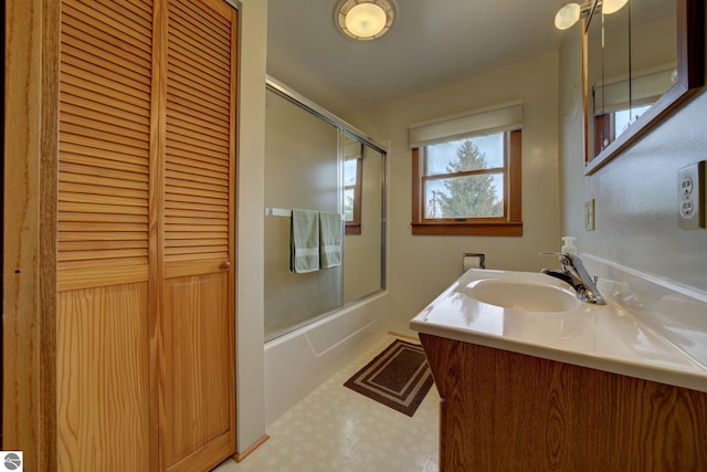 full bathroom featuring vanity, bath / shower combo with glass door, a closet, and tile patterned floors