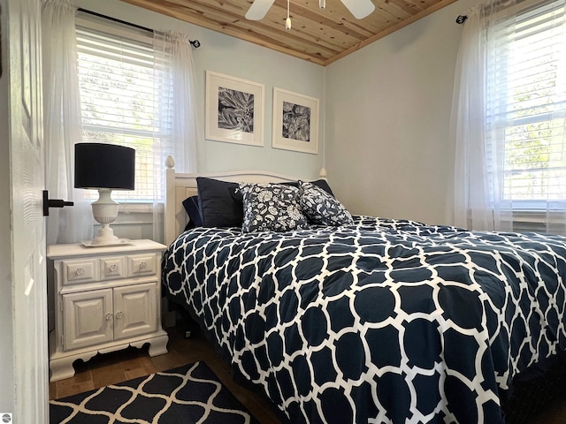 bedroom featuring a ceiling fan, wooden ceiling, wood finished floors, and multiple windows