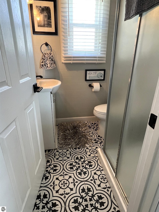 full bathroom featuring tile patterned flooring, vanity, toilet, tile walls, and a stall shower