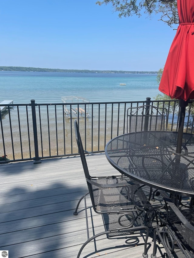 wooden deck featuring a water view and outdoor dining space