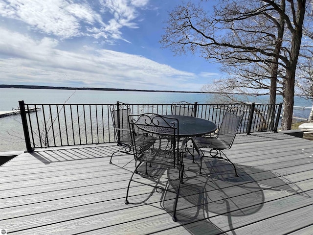 deck featuring outdoor dining area and a water view