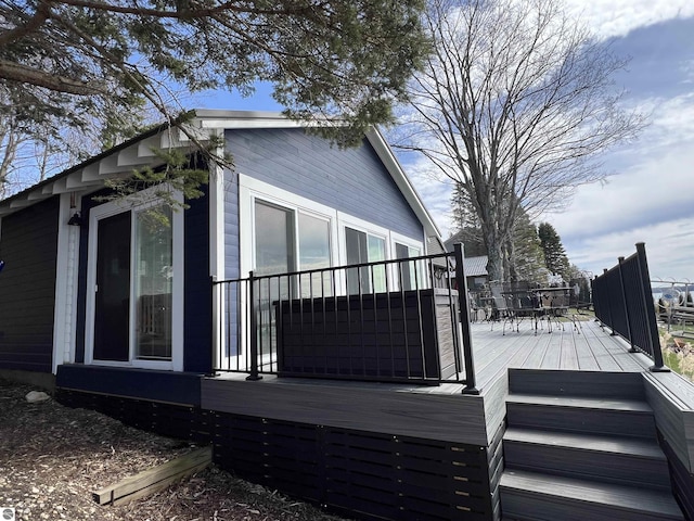 view of property exterior featuring outdoor dining area and a wooden deck