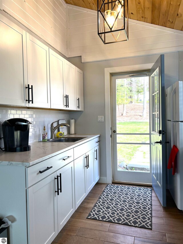 kitchen featuring freestanding refrigerator, wood ceiling, dark wood finished floors, and a sink