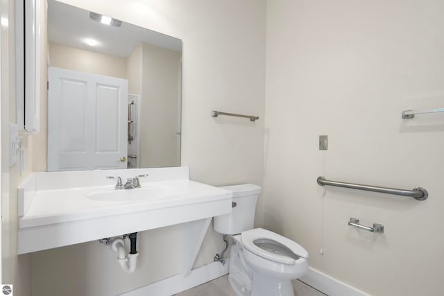 300 S Grand Ave, Leland, MI 49654 - bathroom with toilet, baseboards, visible vents, and a sink