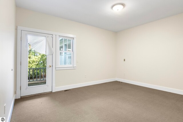 300 S Grand Ave, Leland, MI 49654 - unfurnished room with baseboards and dark colored carpet