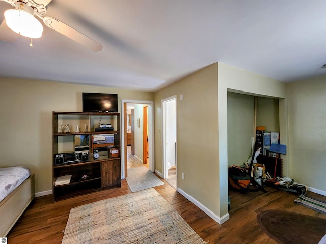bedroom featuring a closet, baseboards, a ceiling fan, and wood finished floors