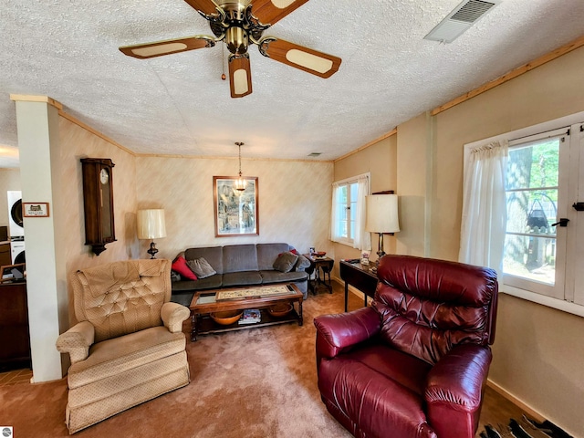 carpeted living room with ceiling fan, a textured ceiling, and visible vents