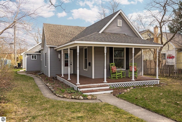 917 Lincoln St, Traverse City, MI 49686 - view of front of home featuring roof with shingles, fence, and a front yard
