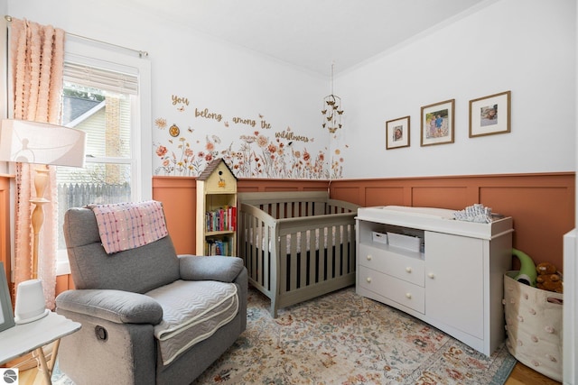 917 Lincoln St, Traverse City, MI 49686 - bedroom featuring a decorative wall, a nursery area, and a wainscoted wall
