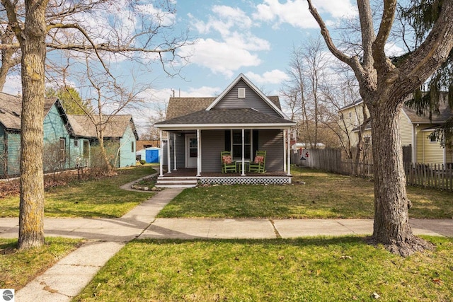 917 Lincoln St, Traverse City, MI 49686 - bungalow-style home with roof with shingles, fence, covered porch, and a front yard
