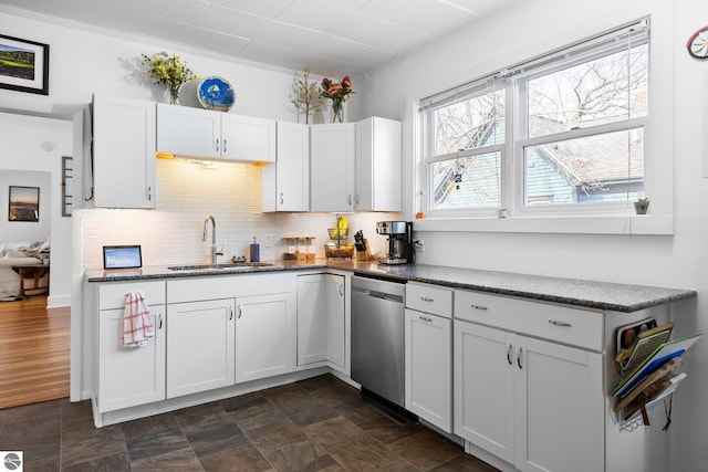 917 Lincoln St, Traverse City, MI 49686 - kitchen featuring a sink, dark stone counters, white cabinetry, tasteful backsplash, and stainless steel dishwasher