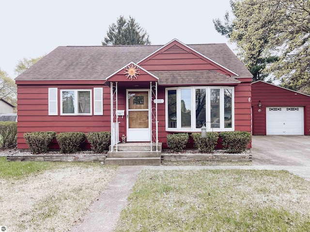 view of front of property with a garage, roof with shingles, and driveway