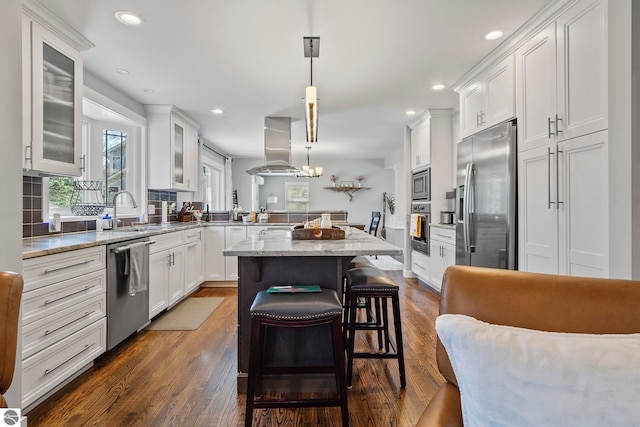 9086 N Tottenham Dr, Traverse City, MI 49685 - kitchen with white cabinets, a peninsula, appliances with stainless steel finishes, and island range hood