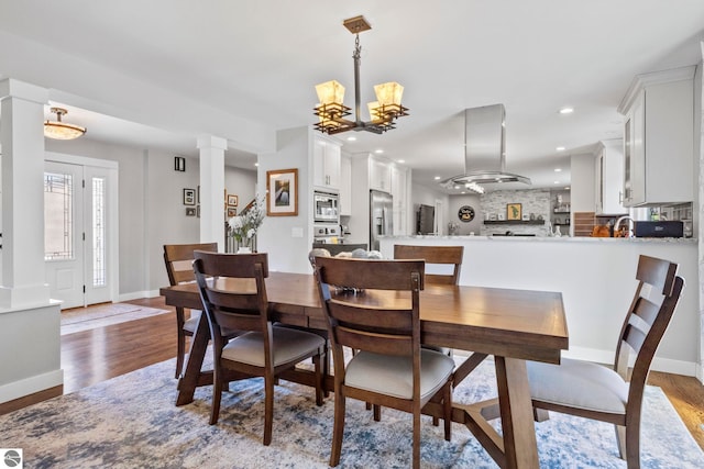 9086 N Tottenham Dr, Traverse City, MI 49685 - dining space with recessed lighting, baseboards, a notable chandelier, and wood finished floors