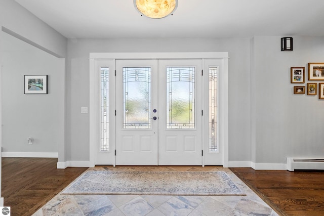 9086 N Tottenham Dr, Traverse City, MI 49685 - entrance foyer featuring baseboards, a baseboard radiator, and a healthy amount of sunlight