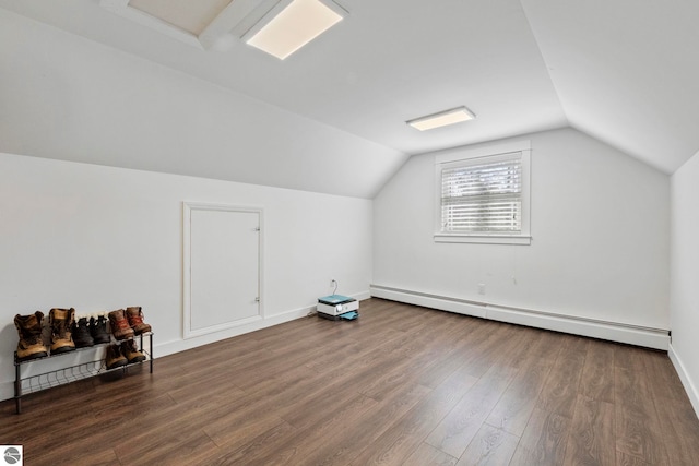 9086 N Tottenham Dr, Traverse City, MI 49685 - additional living space featuring baseboards, a baseboard radiator, lofted ceiling, and wood finished floors