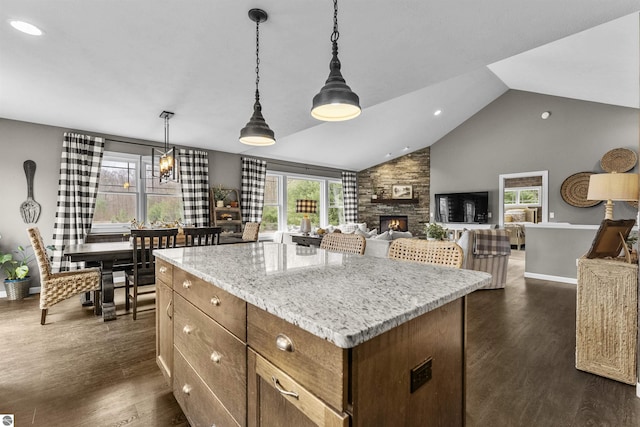 kitchen featuring a center island, dark wood finished floors, hanging light fixtures, and a fireplace