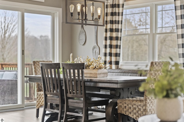 dining area with wood finished floors, a chandelier, and a wealth of natural light
