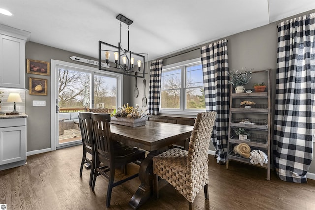 dining area featuring a notable chandelier, plenty of natural light, and wood finished floors