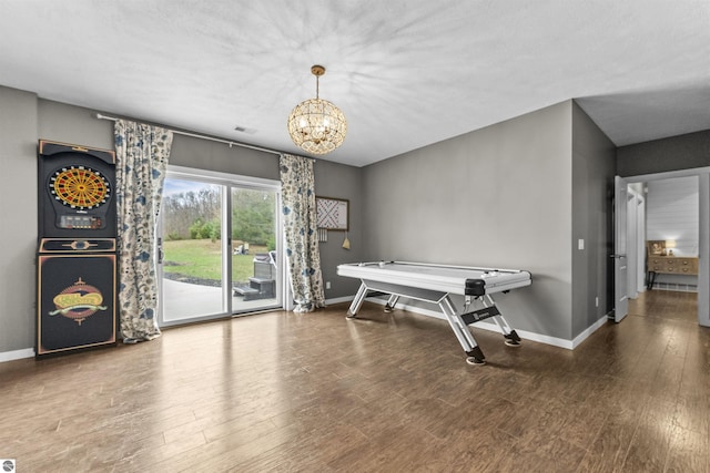 game room with baseboards, a chandelier, wood finished floors, and visible vents