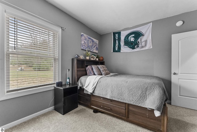 bedroom with baseboards and light colored carpet