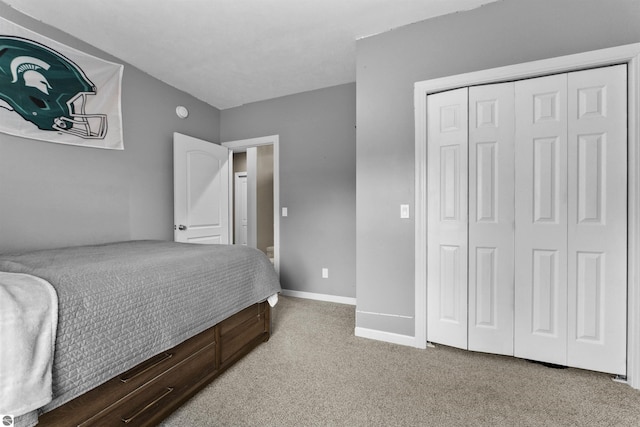 bedroom with baseboards, a closet, and light carpet