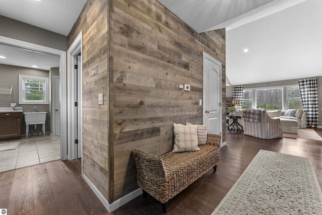 corridor featuring recessed lighting, lofted ceiling, wood finished floors, and wooden walls