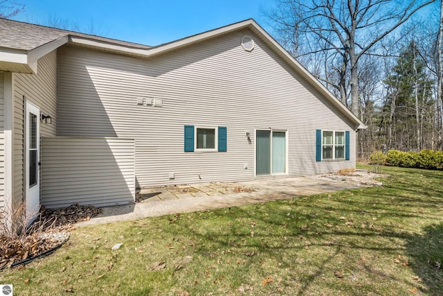 1316 Terra Rd, Traverse City, MI 49686 - rear view of house with a lawn and a patio area