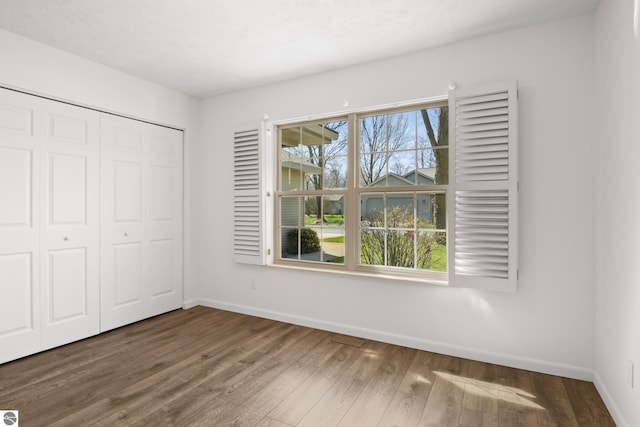 1316 Terra Rd, Traverse City, MI 49686 - unfurnished bedroom featuring baseboards, wood finished floors, and a closet