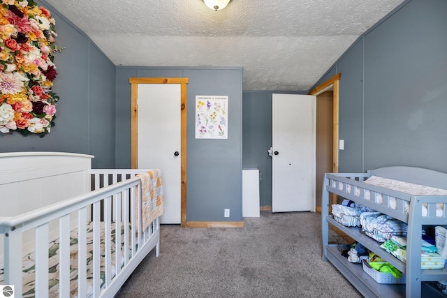 carpeted bedroom with a nursery area and a textured ceiling