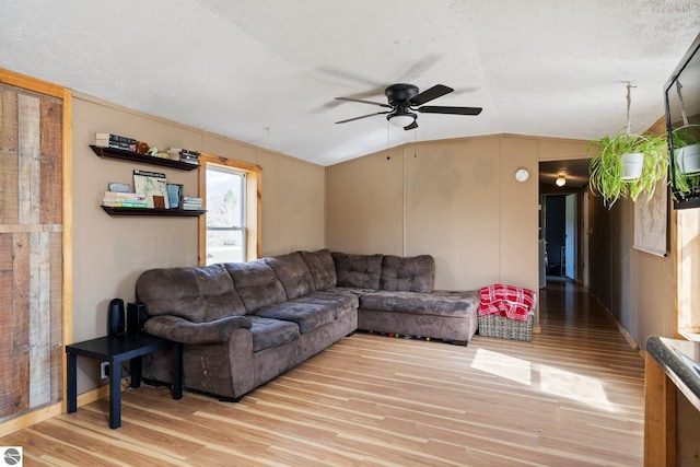 living room with light wood-style floors, ceiling fan, a textured ceiling, and lofted ceiling