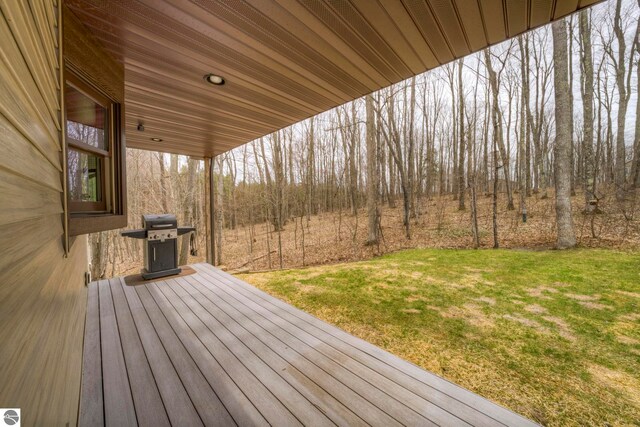 wooden terrace featuring a lawn