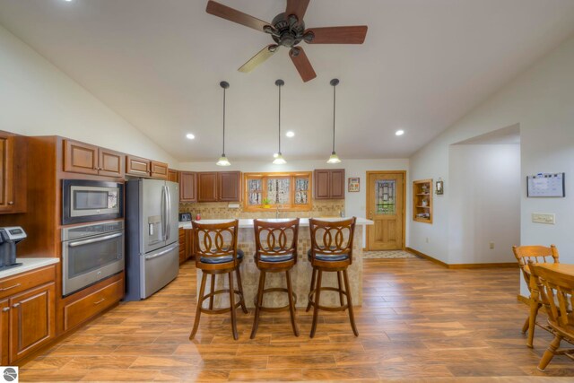 kitchen with light countertops, appliances with stainless steel finishes, and lofted ceiling