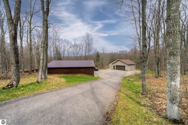 view of front of home with an outbuilding, metal roof, and a garage