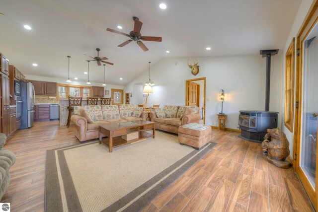 living room with recessed lighting, ceiling fan, light wood finished floors, and a wood stove