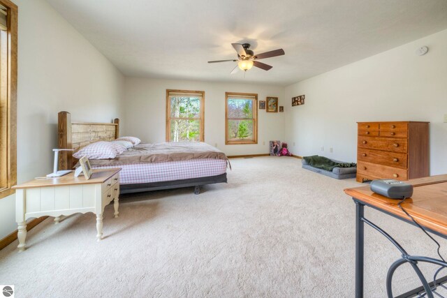 carpeted bedroom featuring baseboards and ceiling fan