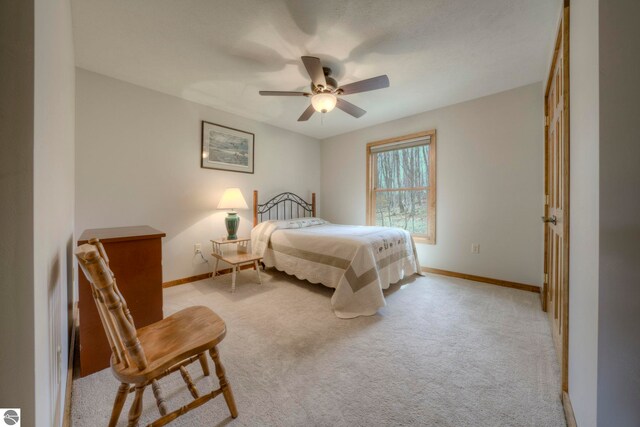 bedroom with baseboards, a ceiling fan, and light colored carpet