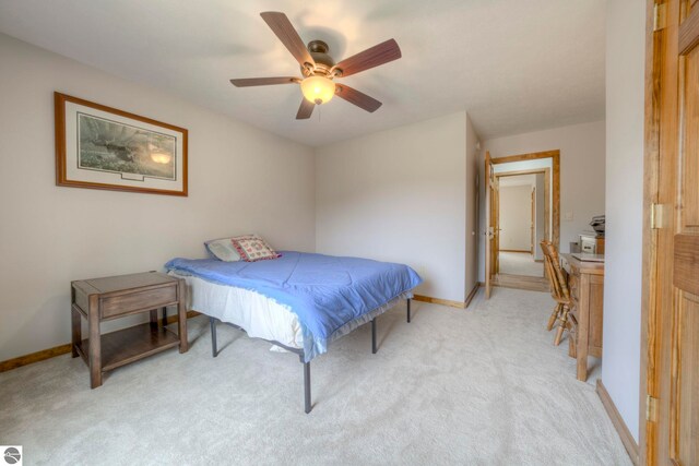 bedroom with baseboards, a ceiling fan, and light carpet