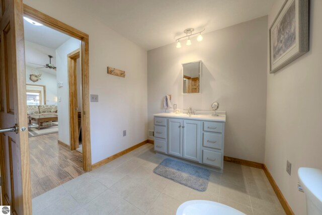 bathroom featuring vanity, ceiling fan, baseboards, and toilet