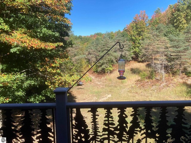 view of yard featuring a view of trees and a balcony