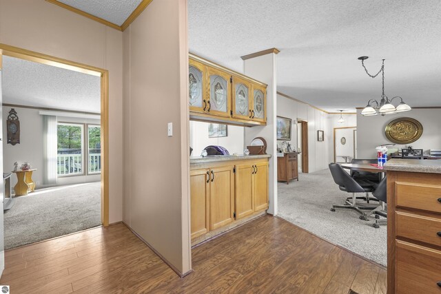 interior space featuring crown molding, pendant lighting, a textured ceiling, and dark wood finished floors