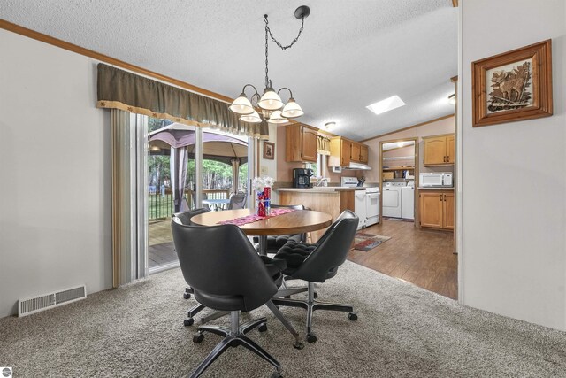 dining space with visible vents, washer and dryer, a textured ceiling, a chandelier, and carpet flooring