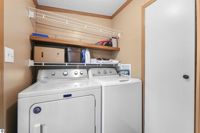 laundry area with separate washer and dryer, ornamental molding, and laundry area