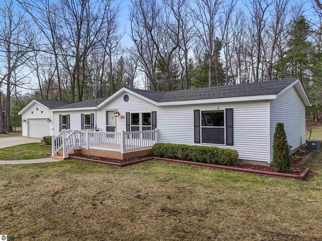 view of front of property with a garage, a front yard, a deck, central AC unit, and concrete driveway