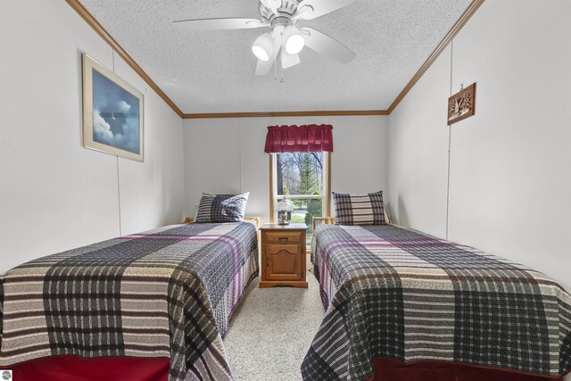 carpeted bedroom with crown molding, a ceiling fan, and a textured ceiling